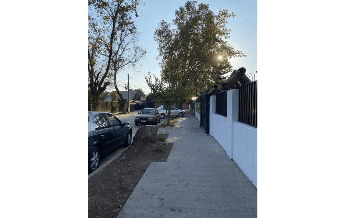 Vista de la calle arbolada frente a la casa estilo colonial en La Cisterna