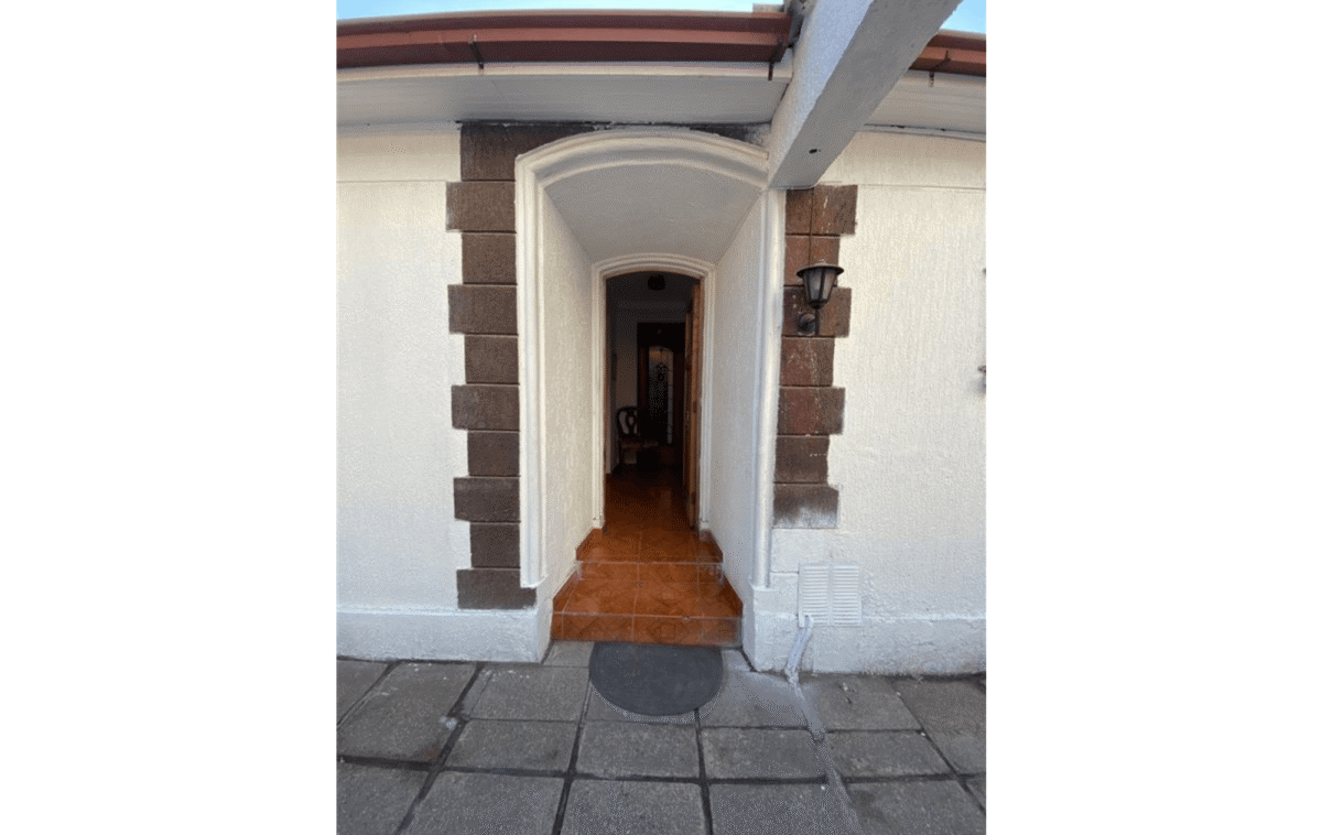 Hall de acceso con arco decorativo y escalón de entrada, casa colonial en La Cisterna