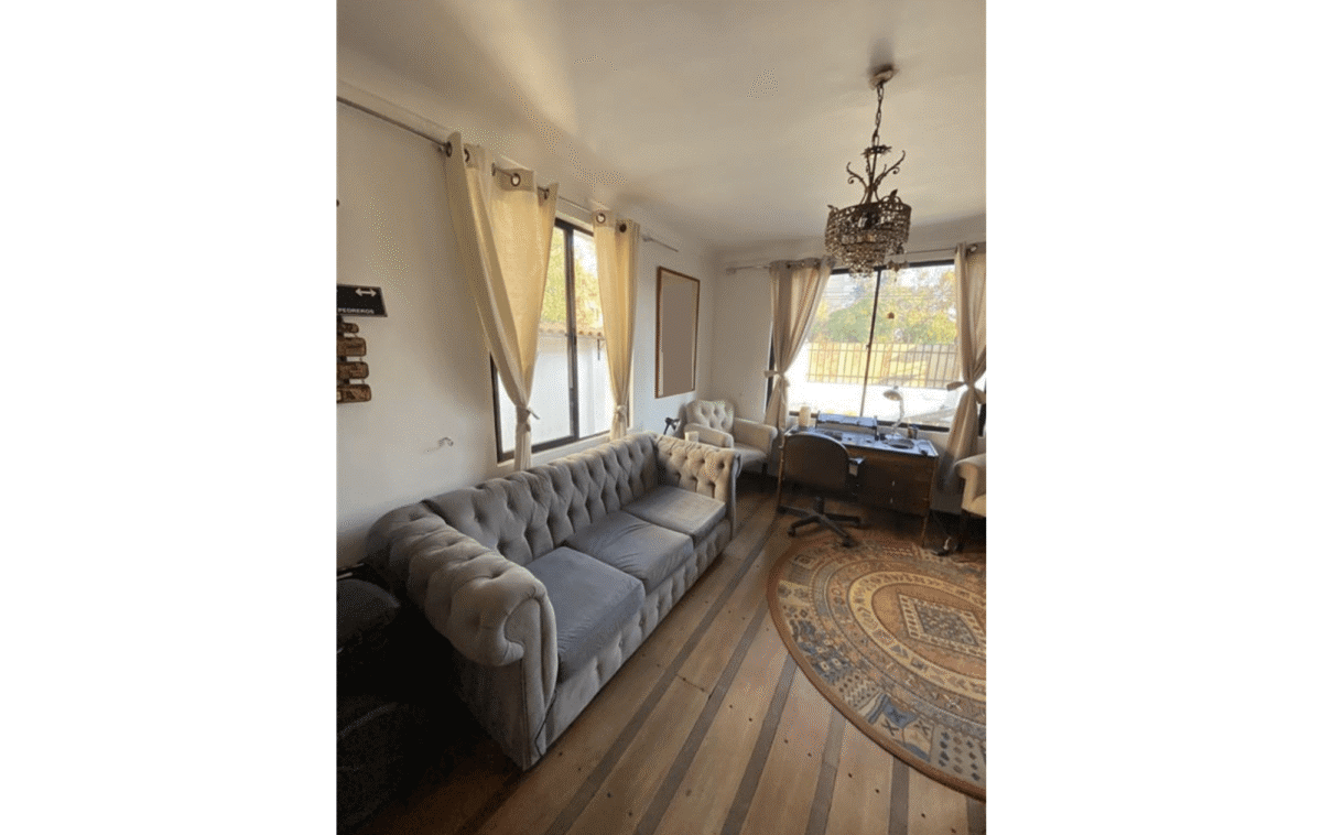 Living con sillón chesterfield y escritorio, casa estilo colonial en La Cisterna