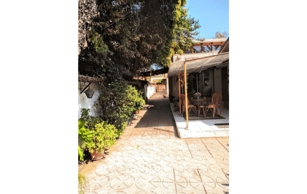 Patio exterior con senda hacia el quincho, casa estilo colonial en La Cisterna