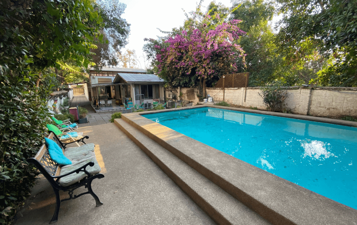 Vista panorámica de la piscina, jardín y área de eventos, casa estilo colonial en La Cisterna