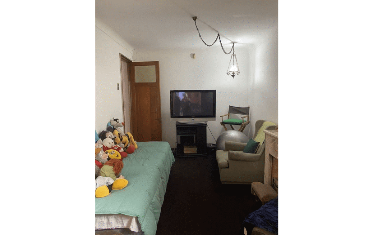 Dormitorio secundario con televisor y sillón, casa estilo colonial en La Cisterna