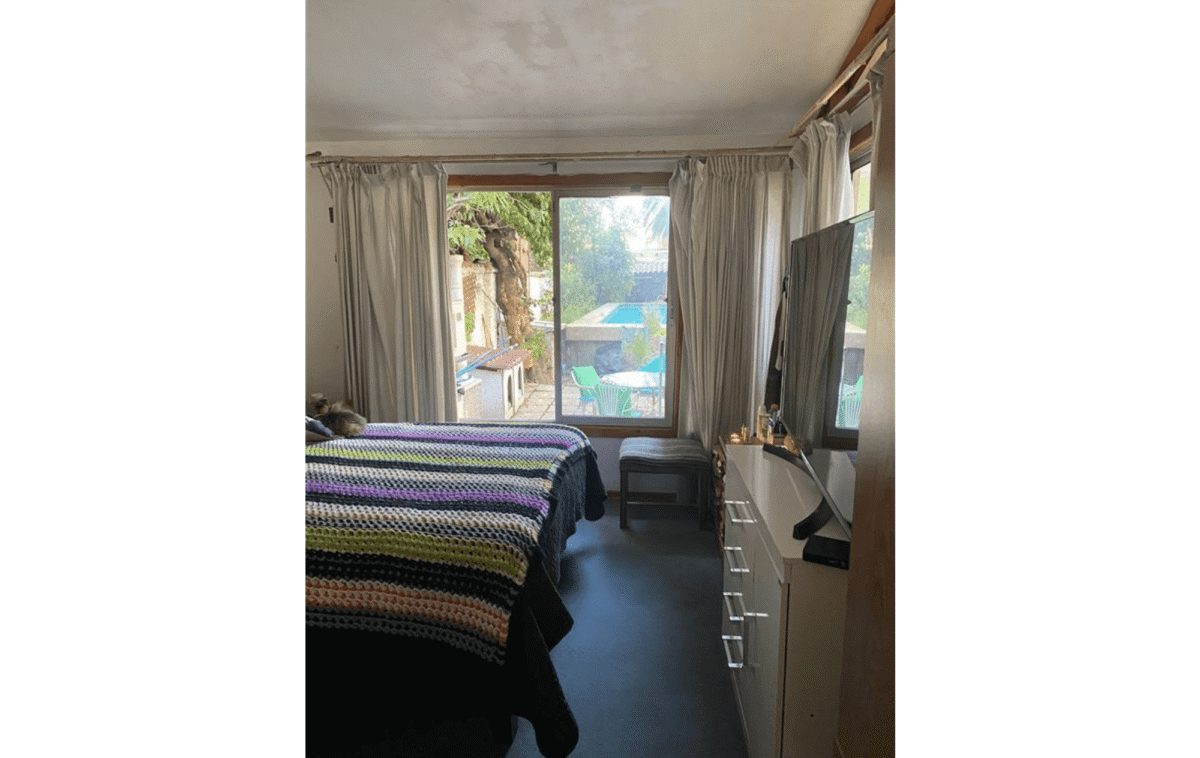 Dormitorio principal con ventanal y vista a la piscina, casa estilo colonial en La Cisterna