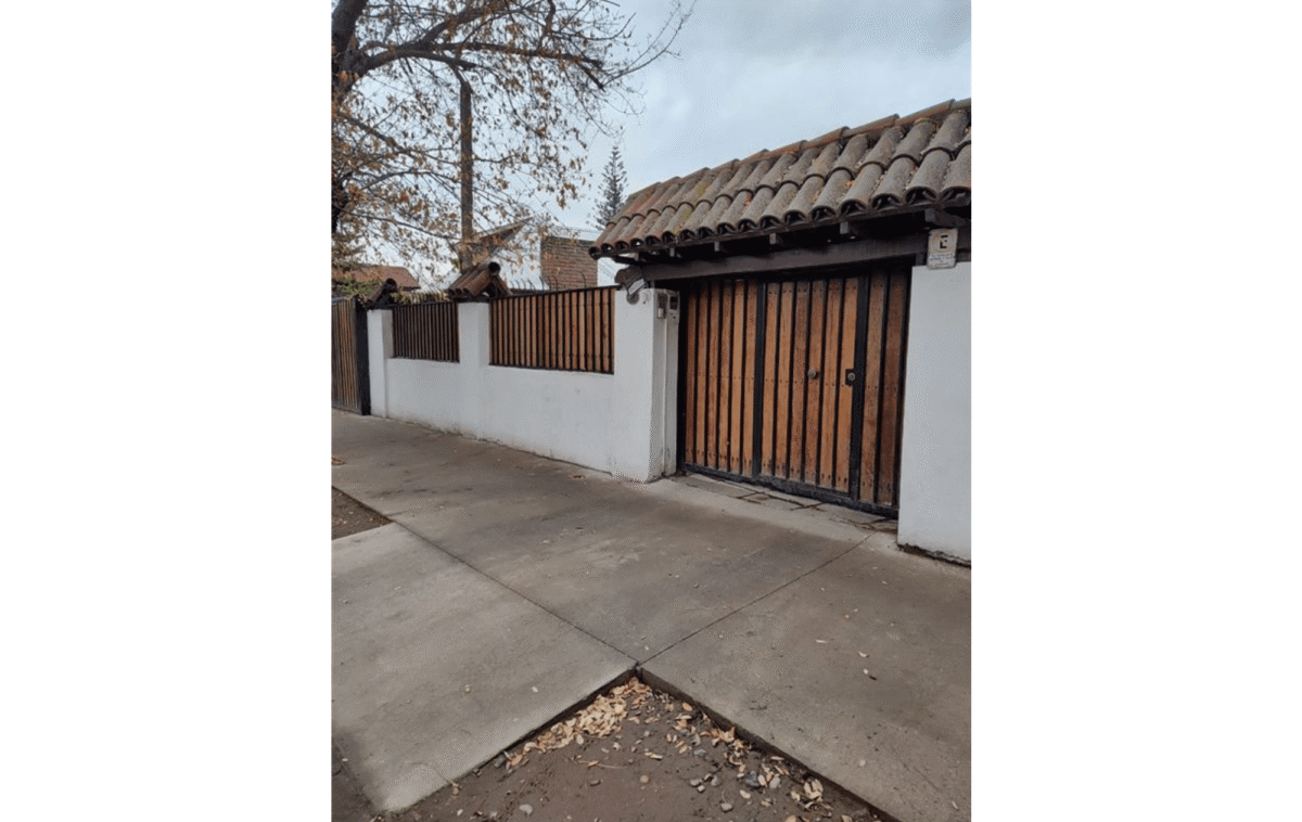 Fachada de la casa colonial con portón de madera y techo de tejas, La Cisterna