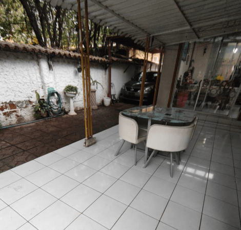 Terraza cubierta con mesa de vidrio y sillas, casa estilo colonial en La Cisterna