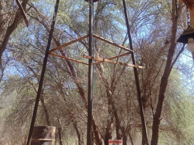 Estructura de soporte junto al pozo de agua entre los árboles, hostal en La Tirana, Pozo Almonte