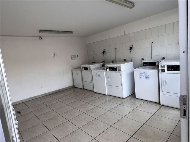 Sala de lavandería común con máquinas, Condominio Nuevo Barrio, Iquique