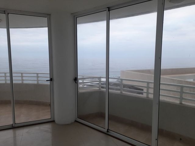 Habitación vacía con puertas correderas hacia el balcón y vista al mar, departamento en Edificio Punta Cavancha, Iquique