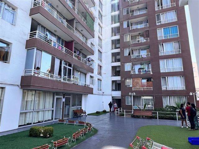 Fachada de las torres del condominio con áreas verdes en el patio interior, Iquique