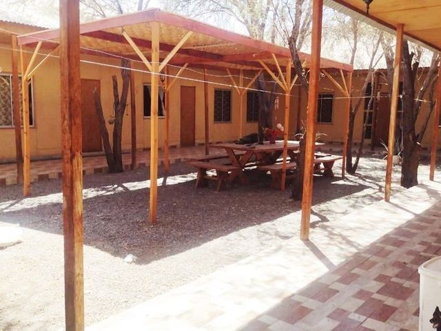Vista amplia del patio central techado con mesa de picnic, hostal en La Tirana, Pozo Almonte