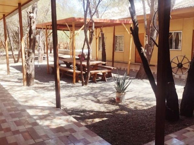 Patio con árboles y fachada del hostal, La Tirana, Pozo Almonte