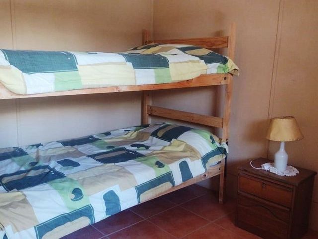 Dormitorio con litera de madera, hostal en La Tirana, Pozo Almonte