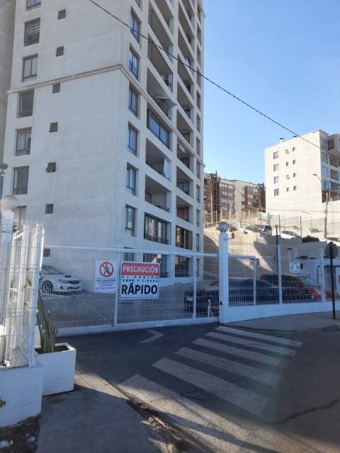 Reja de acceso al condominio Puesta de Sol con cartel de precaución