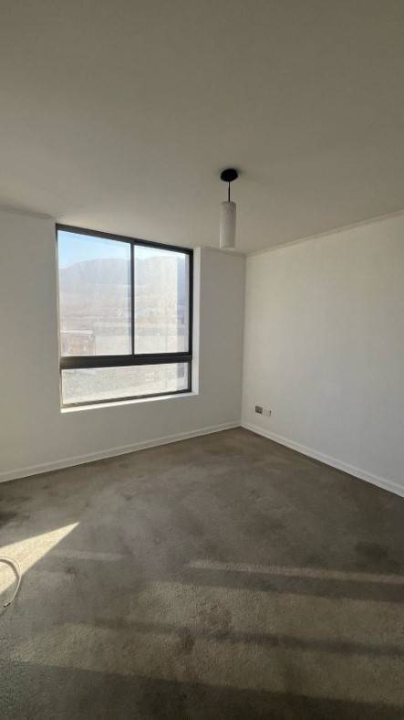 Dormitorio vacío con alfombra y ventana con vista al cerro, departamento Puesta de Sol
