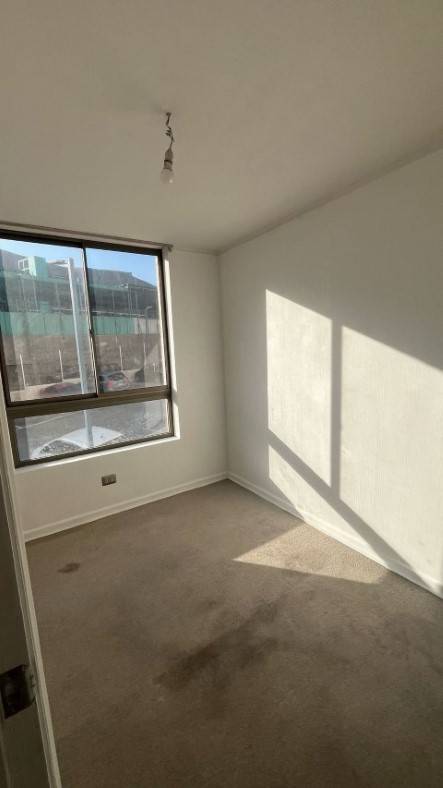 Dormitorio vacío con alfombra y ventana con vista a la calle, departamento Puesta de Sol