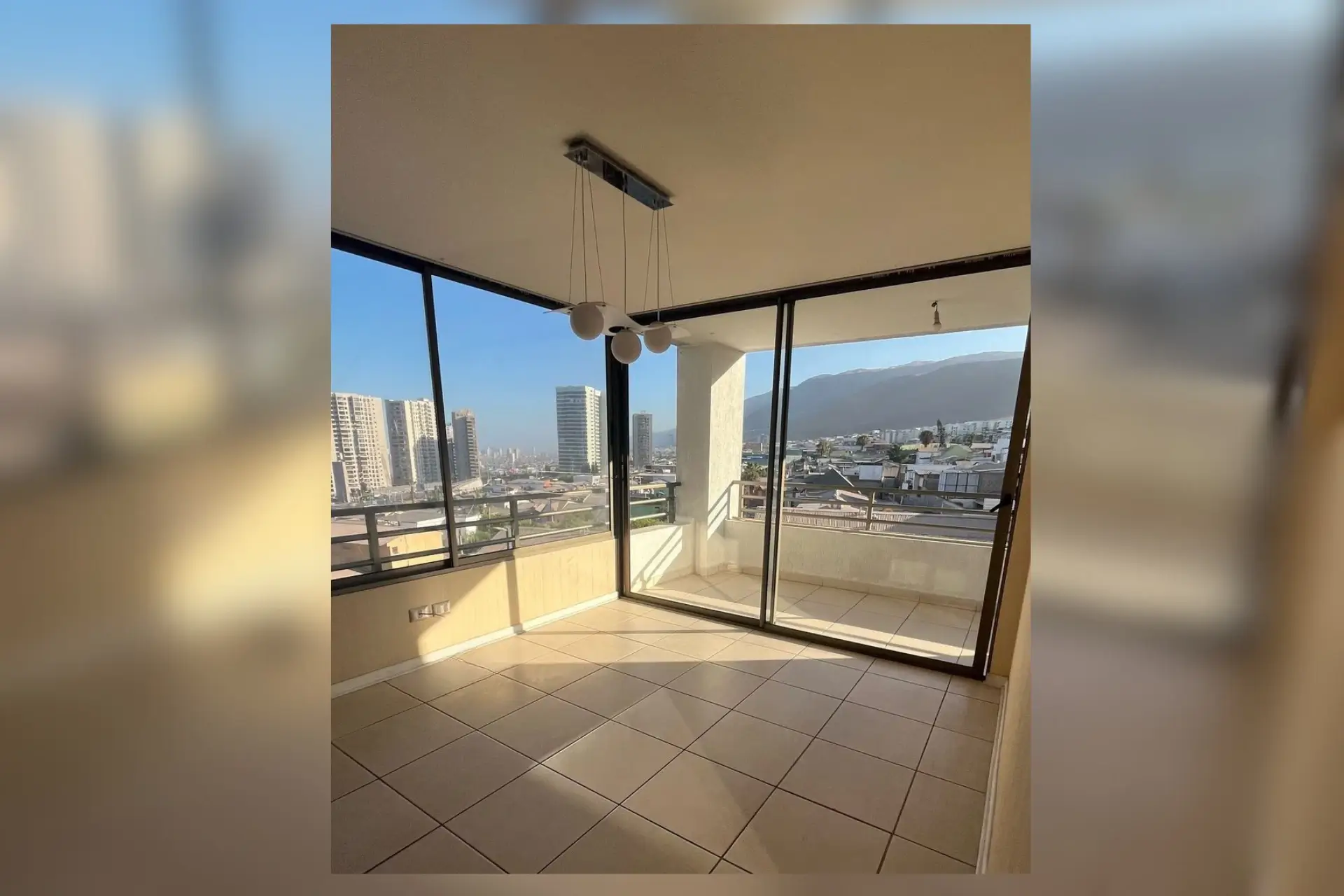 Living con ventanal panorámico y vista a la ciudad y cerros, departamento Puesta de Sol, Iquique