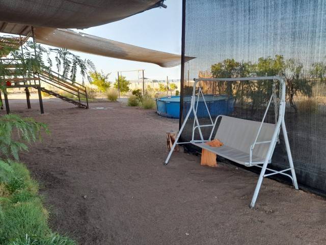 Zona de descanso con hamaca junto a piscina, parcela con casa en Altos de Miraflores, Pica