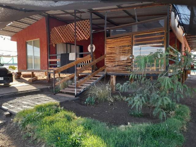 Fachada de la casa con terraza y escalera de acceso, parcela en Altos de Miraflores, Pica