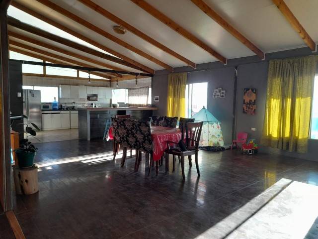 Comedor con mesa y techo de vigas de madera, parcela con casa en Altos de Miraflores, Pica