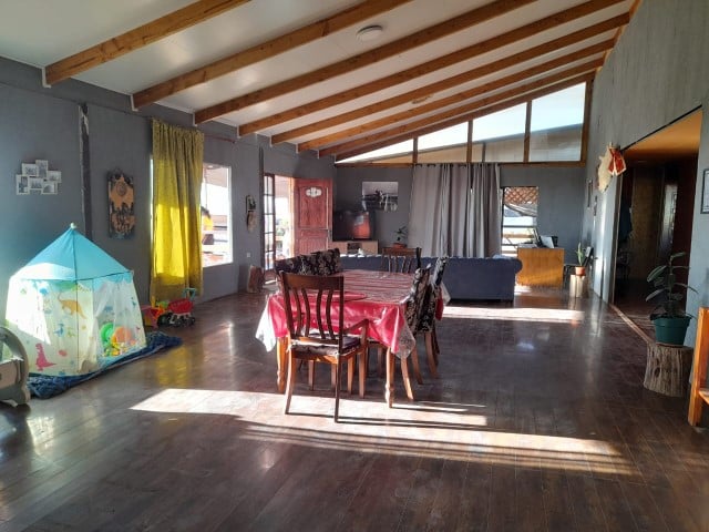Comedor con mesa y sillas, techo de vigas de madera, parcela con casa en Altos de Miraflores