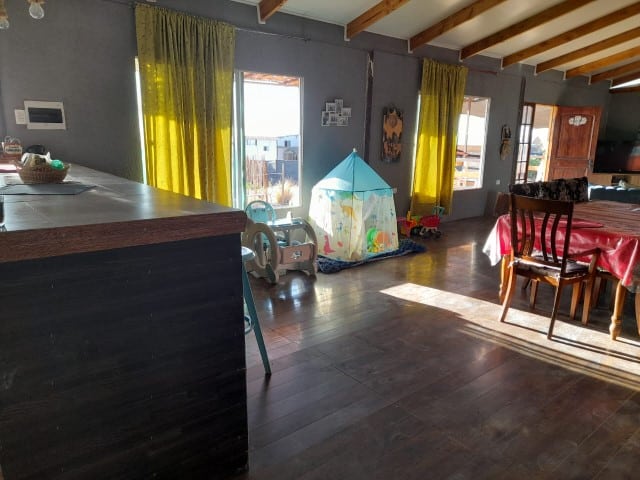 Living comedor con mesón y área infantil, parcela con casa en Altos de Miraflores, Pica