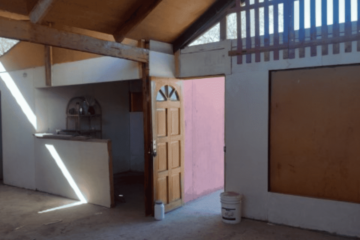 Puerta de entrada de madera junto a la cocina rústica de la cabaña, parcela en La Tirana, Pozo Almonte