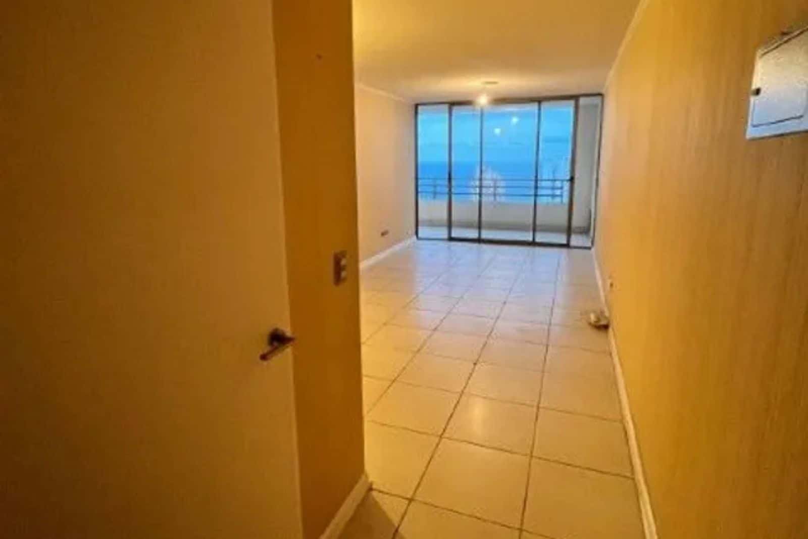 Pasillo interior con vista nocturna al mar, departamento en Iquique