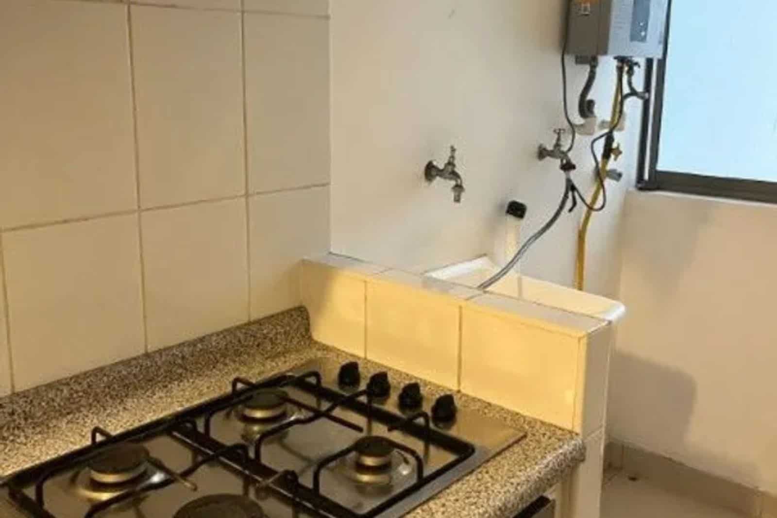 Cocina con encimera de granito y cocina a gas, departamento con vista al mar en Iquique