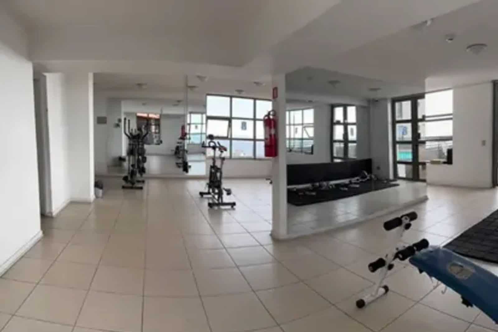Sala de gimnasio del edificio con máquinas de ejercicio, departamento con vista al mar en Iquique