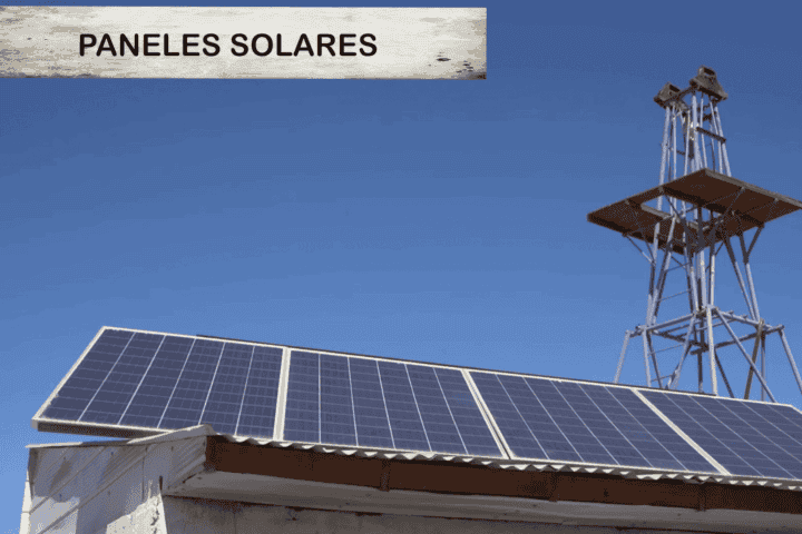 Paneles solares instalados sobre techo junto al molino de viento, sistema de riego solar del terreno en La Huayca, Pozo Almonte