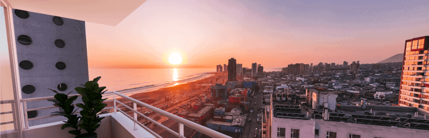 Vista panorámica al atardecer desde balcón en piso alto, Edificio Brava, Iquique