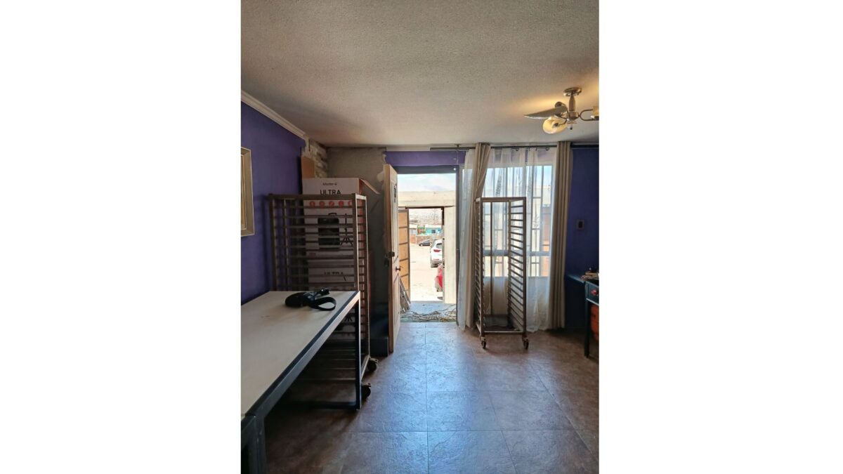 Sala de taller con estanterías y salida al patio, casa en venta en Alto Hospicio