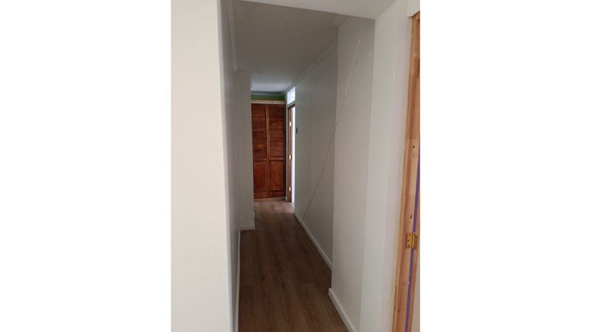 Pasillo interior con piso de madera y acceso a closet, casa en Alto Hospicio