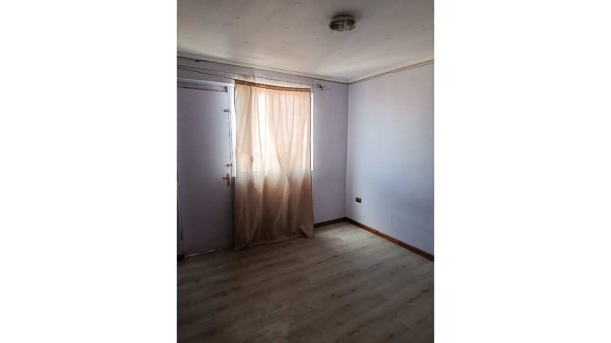 Dormitorio vacío con cortina y piso laminado, casa en venta en Alto Hospicio