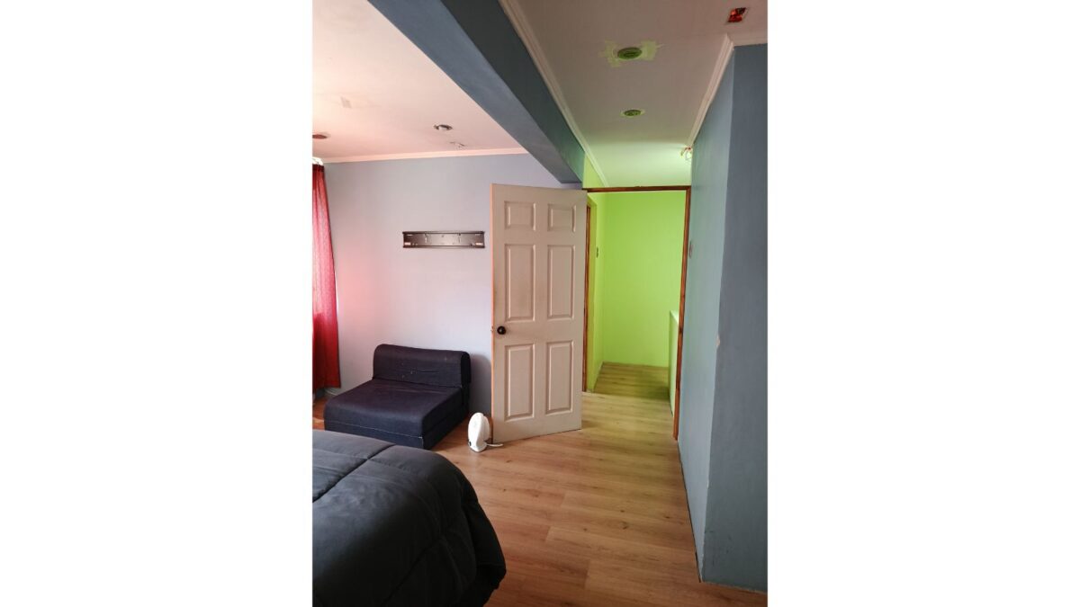 Dormitorio con sofá y acceso a escalera interior, casa en venta en Alto Hospicio