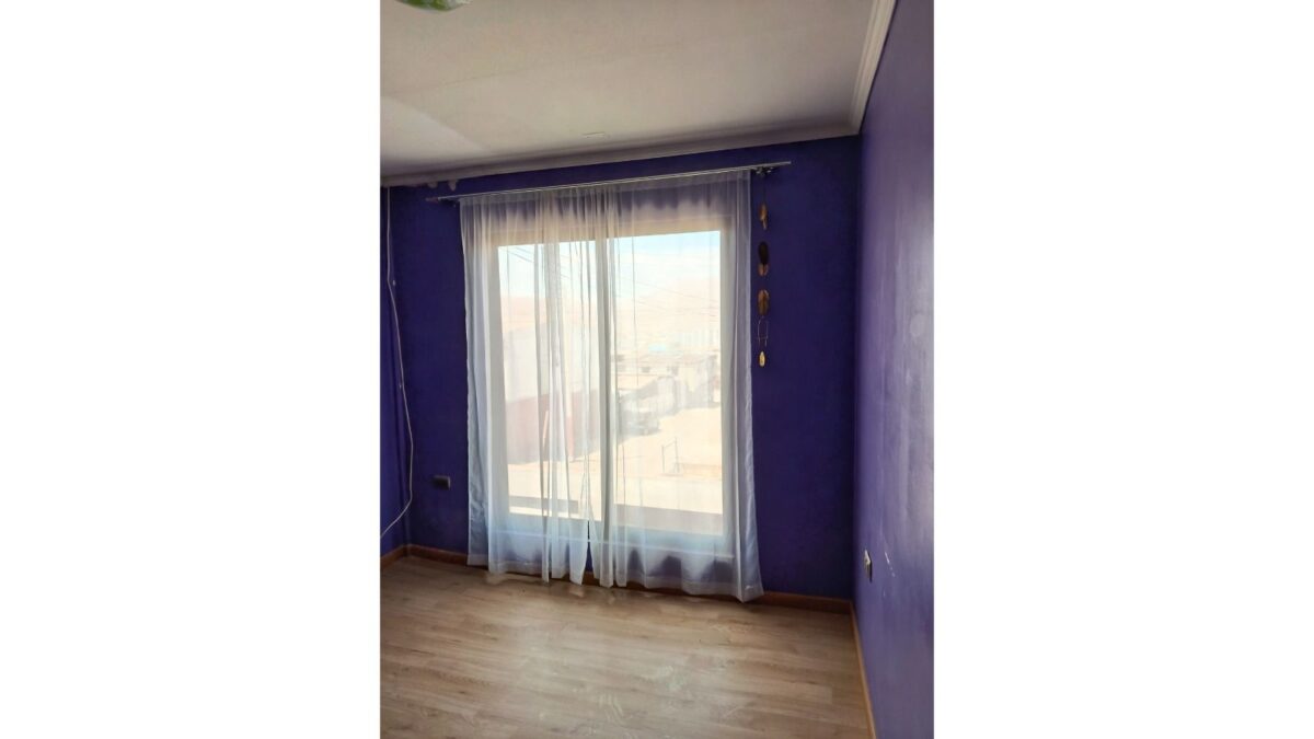 Dormitorio vacío con ventana y cortinas, casa en venta en Alto Hospicio