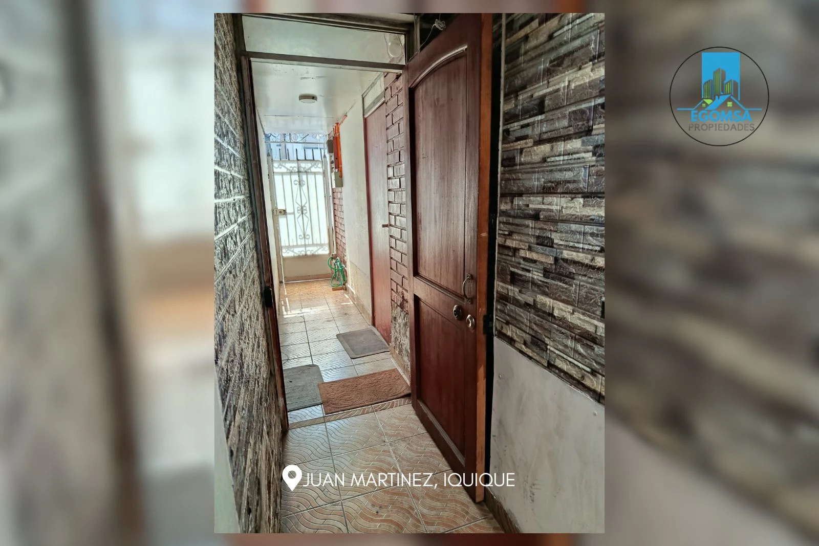 Pasillo interior con puerta de acceso hacia la calle Juan Martínez, Iquique