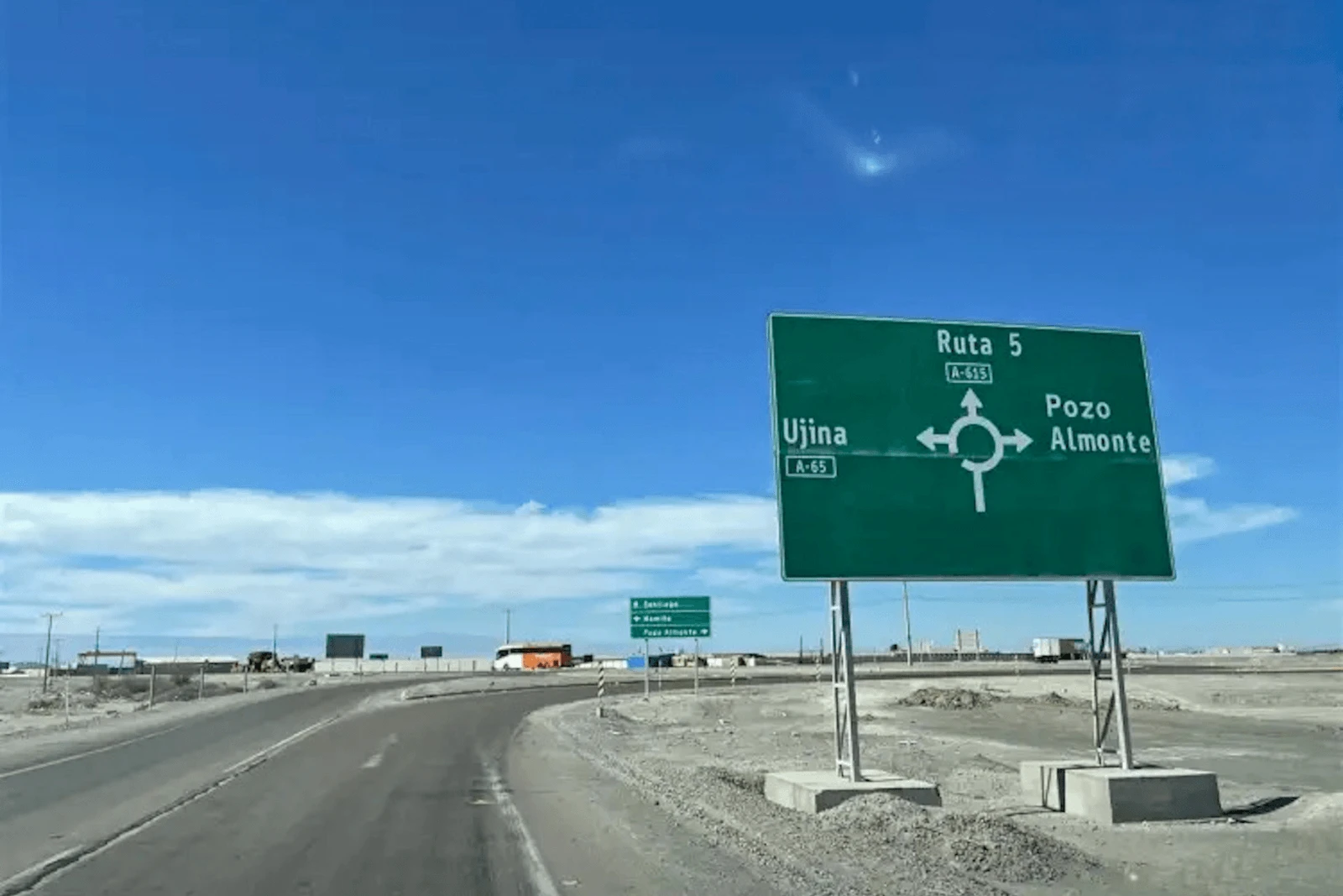 Señal de rotonda indicando Ruta 5, Ujina y Pozo Almonte, cerca del terreno industrial en Pozo Almonte