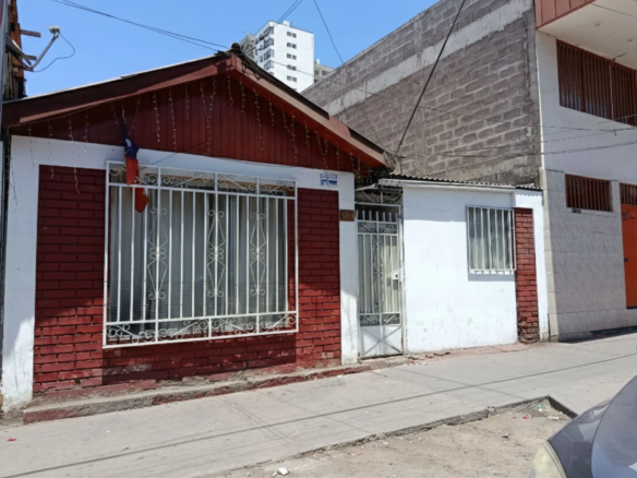 Fachada de la casa con reja y ventanas enrejadas, sector Juan Martínez, Iquique