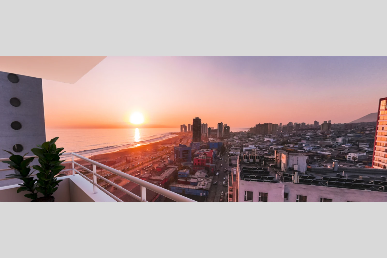 Vista panorámica al atardecer desde balcón en piso alto hacia la costa y la ciudad, Edificio Brava, Iquique