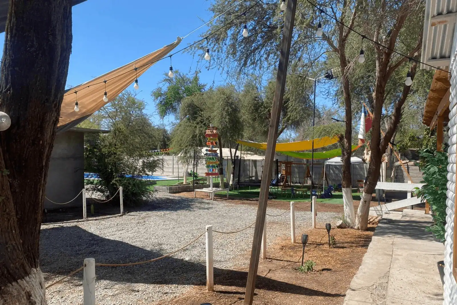 Vista general del terreno con tamarugos, guirnaldas de luces y zona de juegos infantiles, parcela en La Huayca, Pozo Almonte