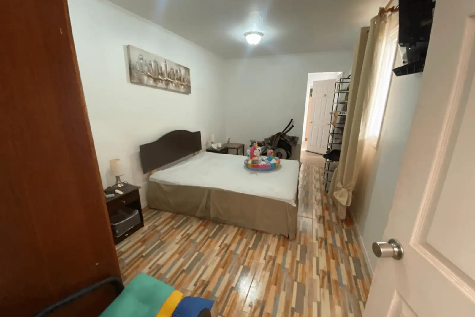 Dormitorio con piso símil madera y cama matrimonial, casa Altos de Pica