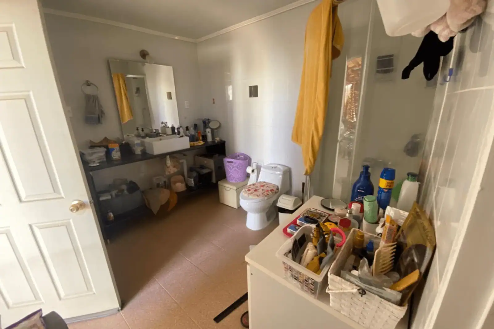 Baño principal con mueble, espejo y ducha con puerta de vidrio