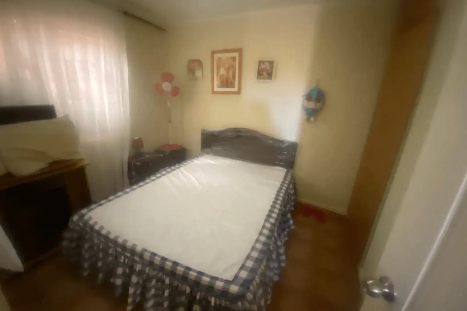 Dormitorio con cama matrimonial y cubrecama a cuadros, casa Altos de Pica