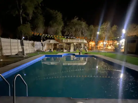 Otra vista nocturna de la piscina iluminada, parcela en La Huayca, Pozo Almonte