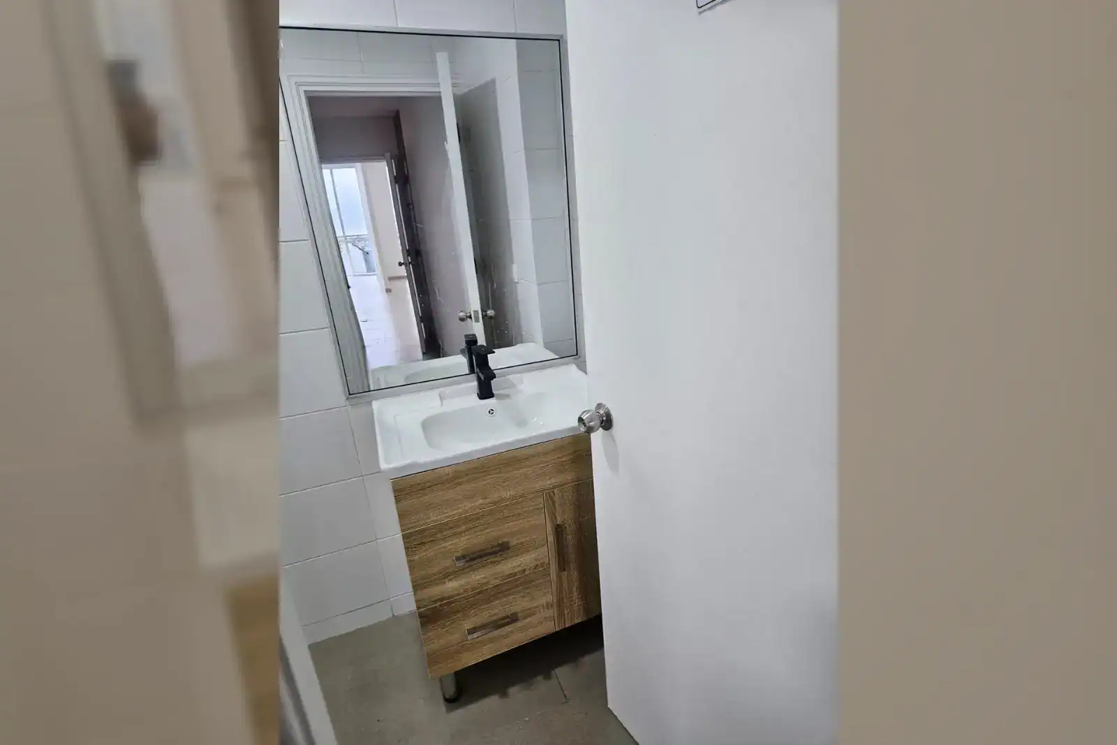 Baño equipado con lavamanos y mueble de madera, oficina en Torre Capital, Iquique