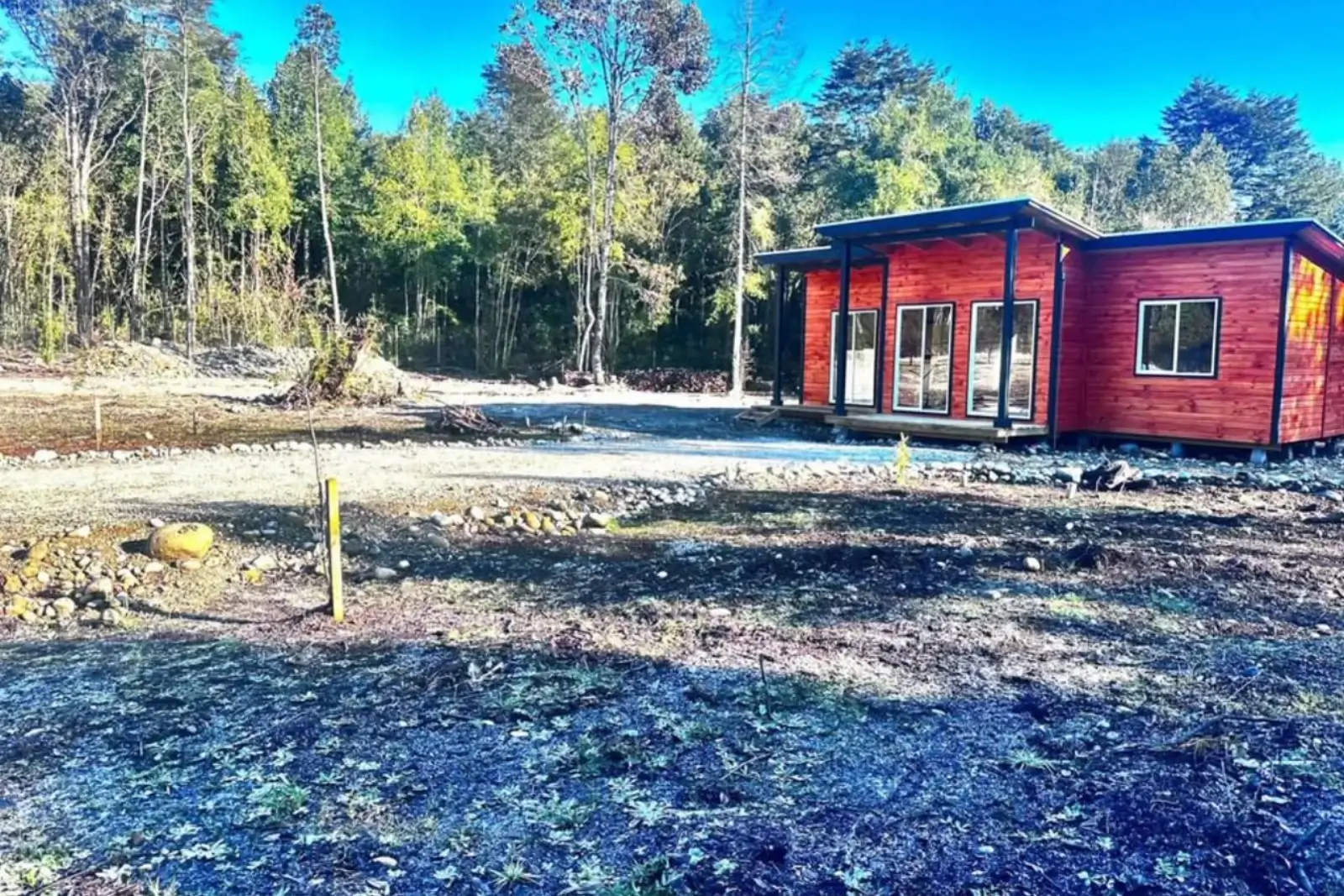 Fachada de la segunda casa independiente, con revestimiento de madera y galería cubierta, Club de Campo, Puerto Varas
