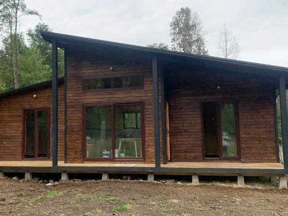 Fachada de la casa principal, con terraza cubierta y ventanales, Club de Campo, Puerto Varas
