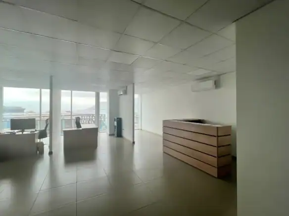 Recepción con mesón de madera y vista al puerto, oficina corporativa en Torre Capital, Iquique